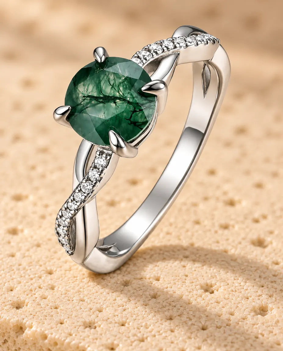 Bague Agate Mousse Ronde - posée debout sur une surface claire texturée