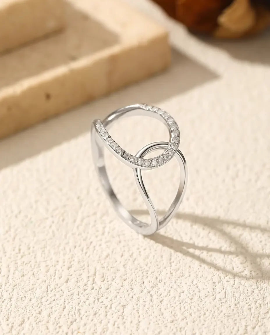 Bague Cercles Entrelacés en Argent 925 - posée debout sur une surface claire texturée