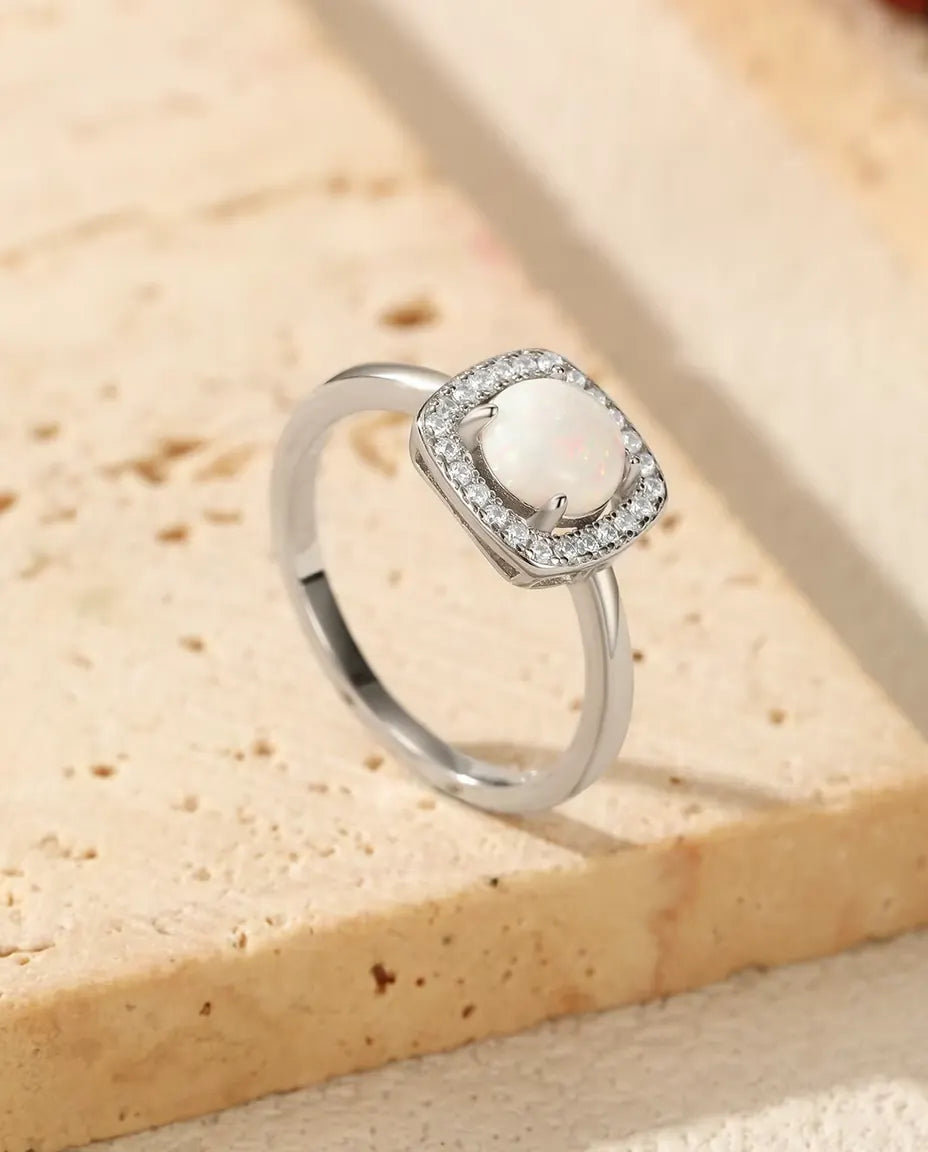 Bague Opale Halo en Argent 925 - posée sur le rebord d’une dalle de travertin