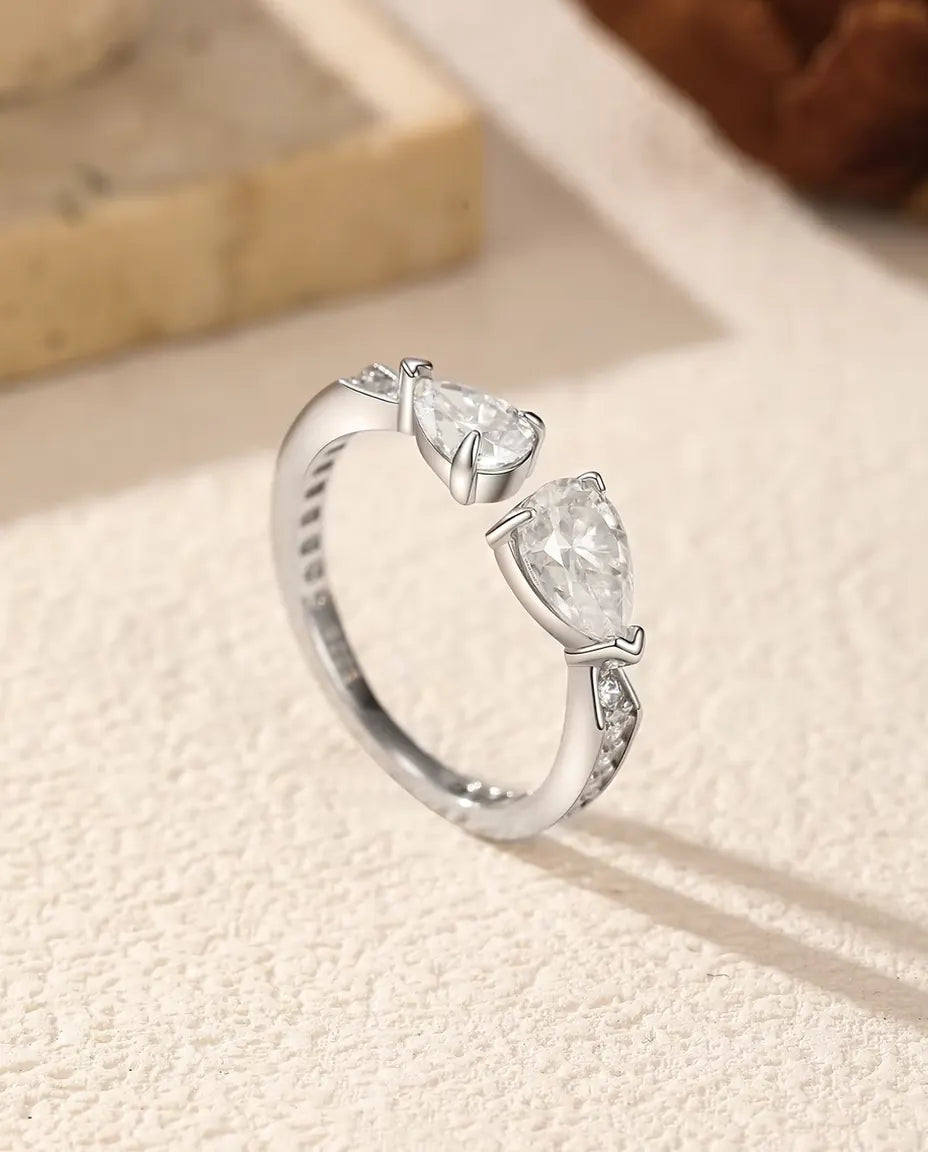 Bague Toi et Moi Moissanite en Argent 925 - posée debout sur une surface claire texturée