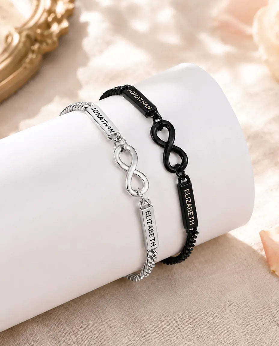Bracelets Couple Personnalisés avec 2 Prénoms Gravés - Bracelets Infini Assortis Argenté et Noir - paire assortie sur un présentoir