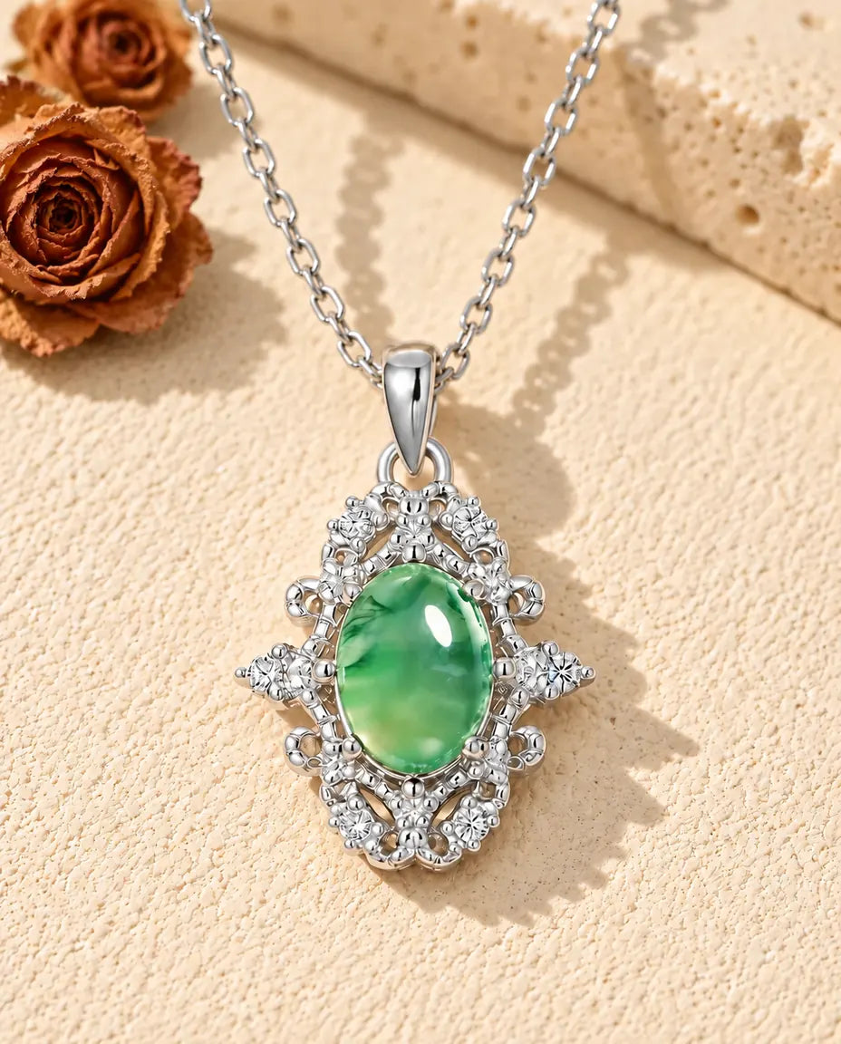 Collier Agate Mousse Ovale en Argent 925 - posé sur une surface claire texturée près d’un bloc de travertin