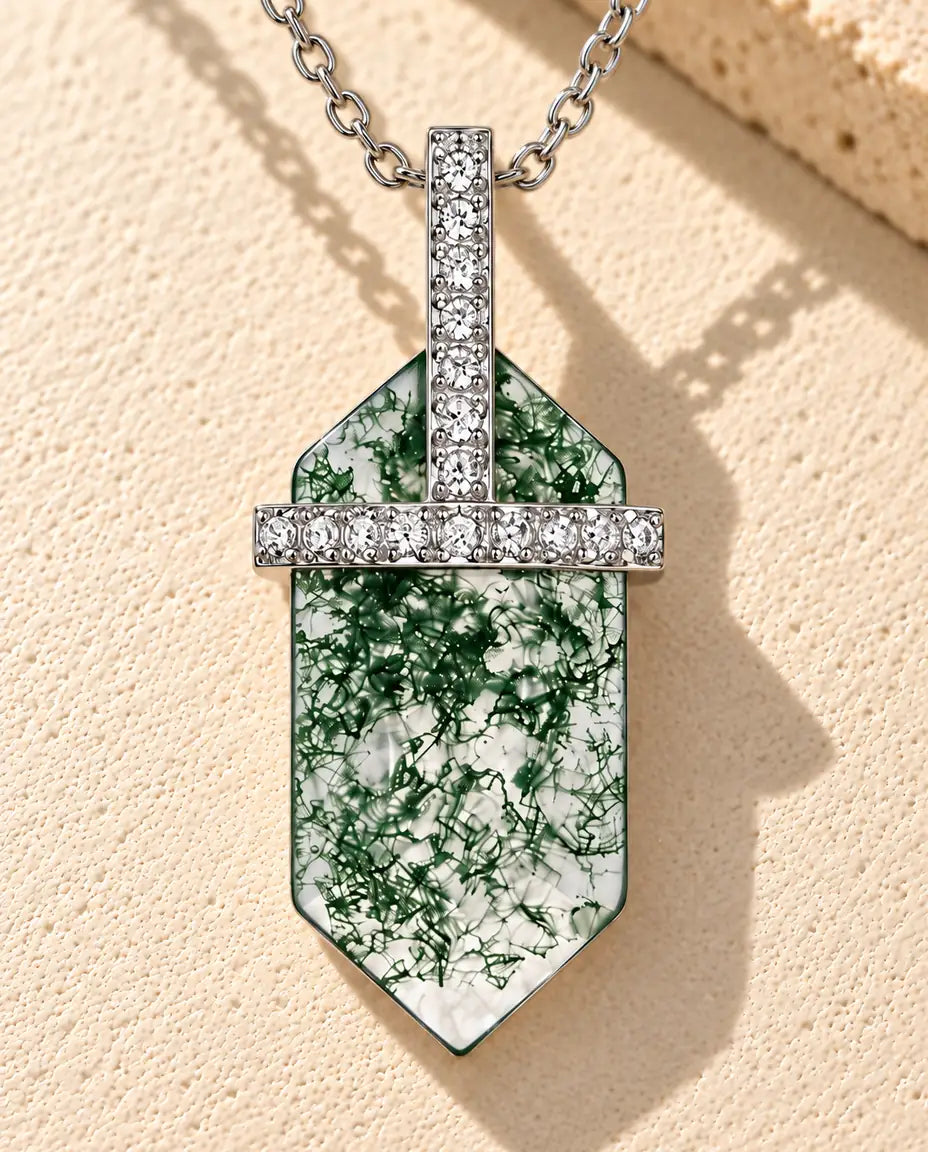 Collier Agate Mousse Hexagonale en Argent 925 - posé sur une surface claire texturée près d’un bloc de travertin