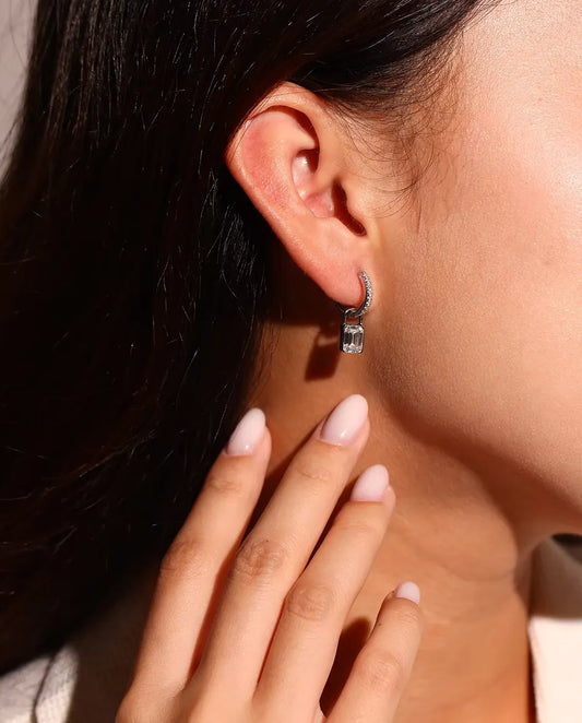 Boucles d’Oreilles Créoles Cadenas Moissanite en Argent 925 - portées à l’oreille par un mannequin, gros plan