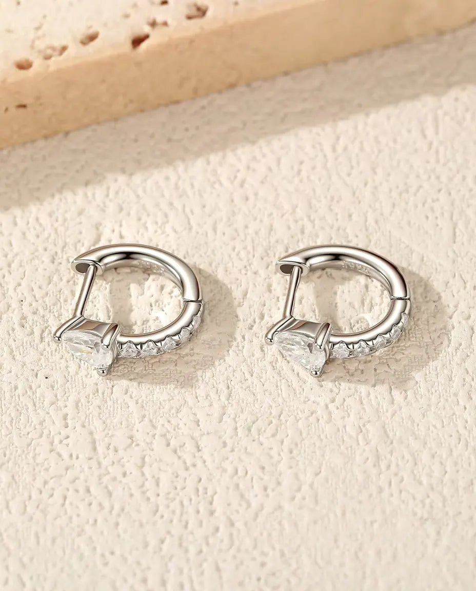 Mini Créoles Moissanite Poire en Argent 925 - la paire posée sur une surface claire texturée