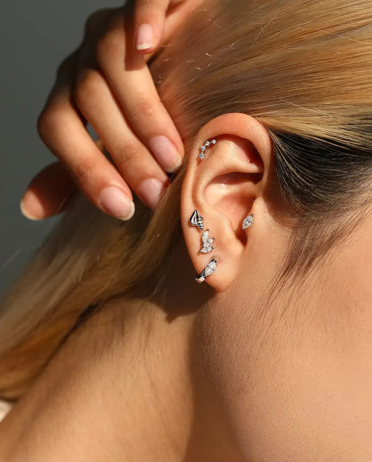 Puces d’Oreilles Coquillage en Spirale en Argent 925 - portée par un mannequin, main derrière la tête