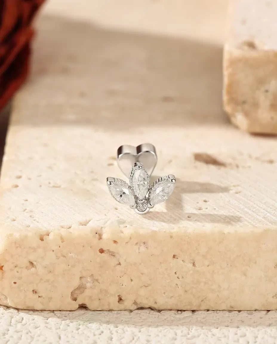 Puces d’Oreilles Lotus Moissanite Marquise en Argent 925 - posée sur le rebord d’une dalle de travertin