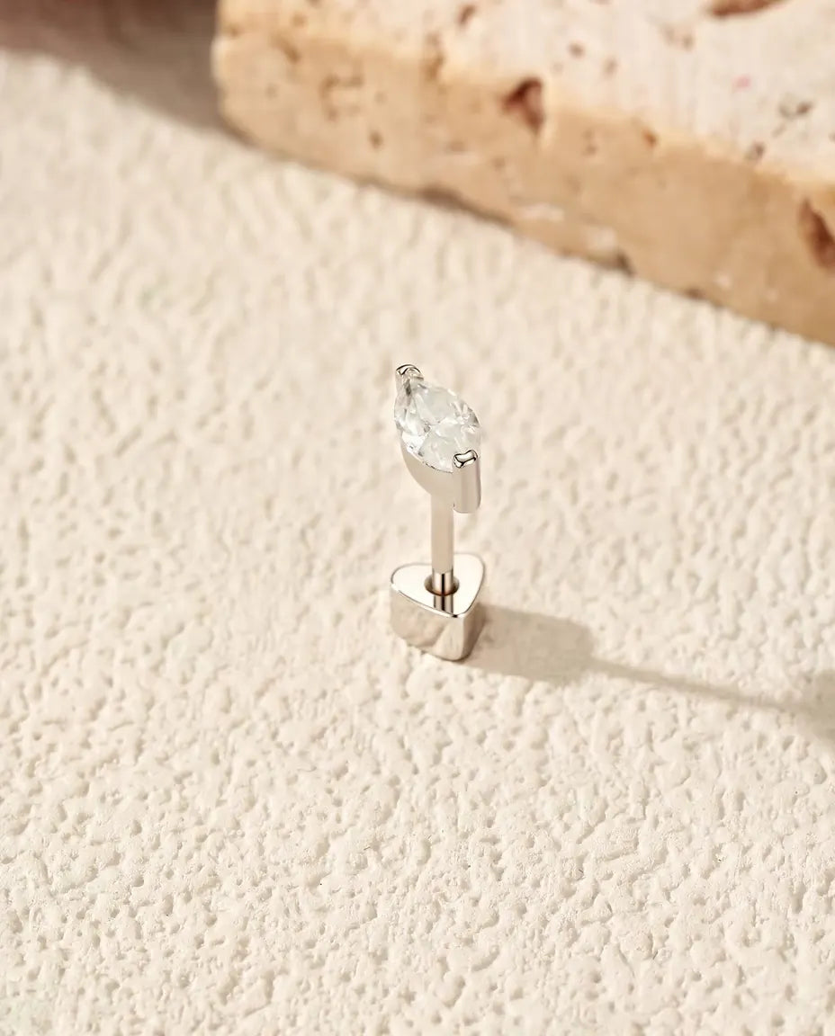 Puces d’Oreilles Moissanite Marquise en Demi-Serti Clos - debout sur son fermoir en forme de cœur, sur une surface claire texturée