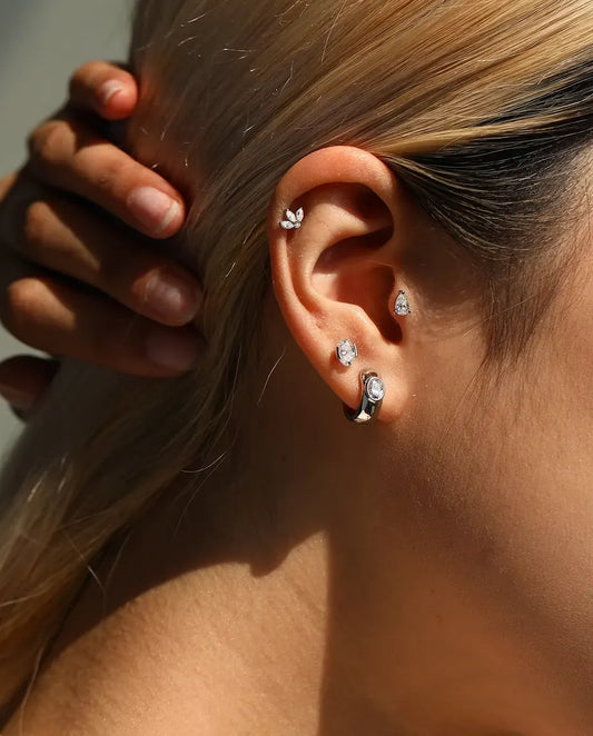 Puces d’Oreilles Moissanite Ovale Serti Latéral en Argent 925 - portée par un mannequin, main derrière la tête