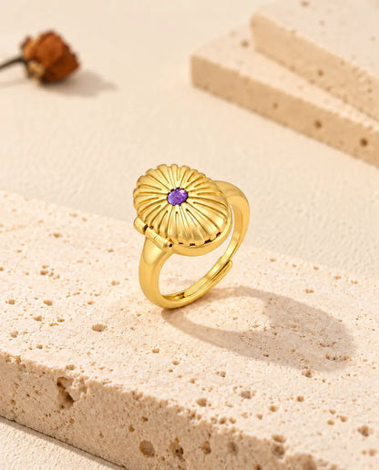 Bague médaillon ovale fermée, posée debout sur un bloc de travertin