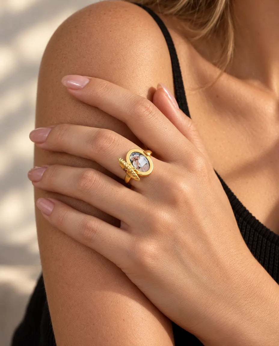 Femme portant la bague médaillon ovale ouverte sur la photo qu'elle renferme