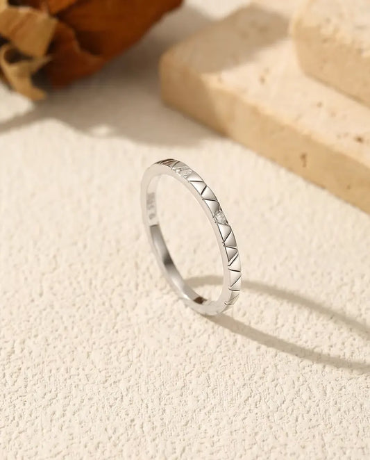 Bague Moissanite Empilable en Argent 925 - posée debout sur une surface claire texturée