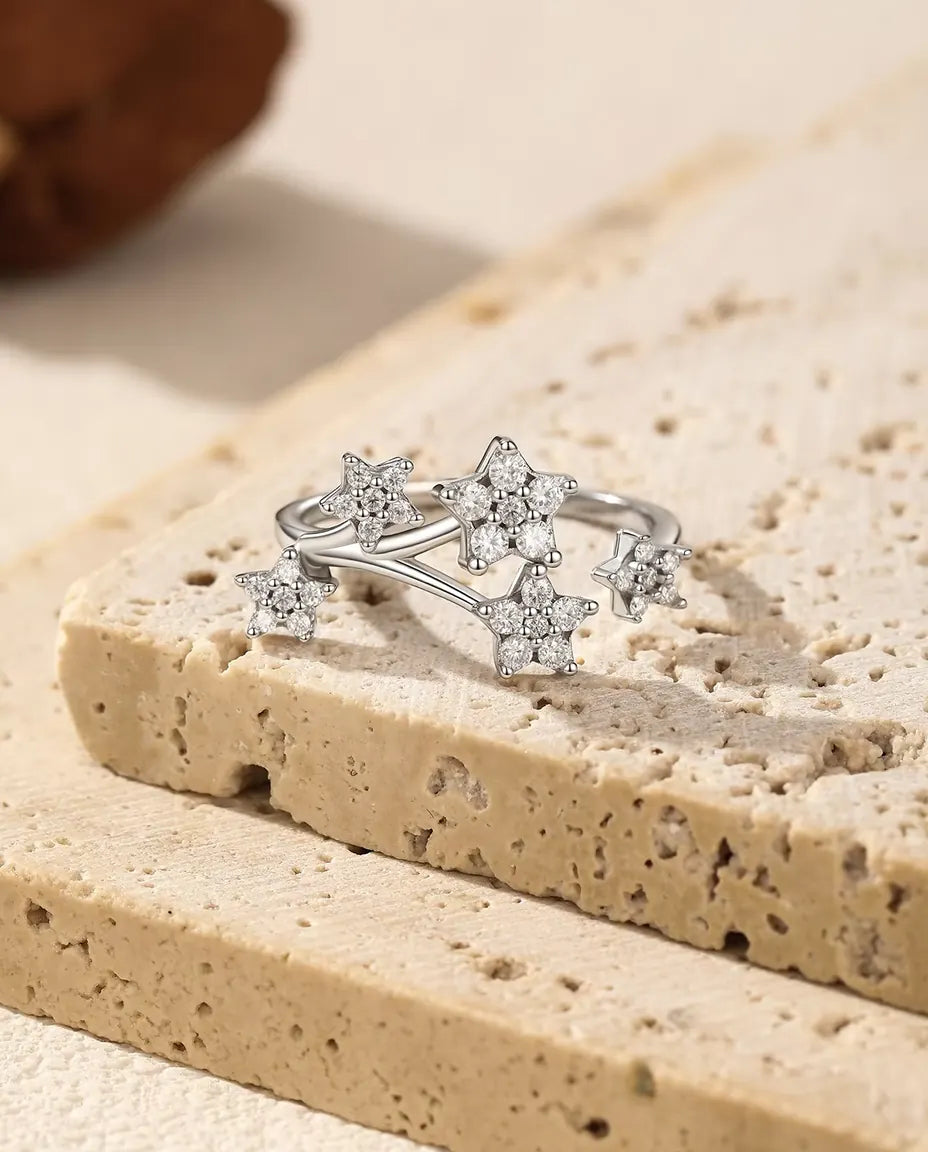Bague Moissanite Étoiles en Argent 925 - posée sur le rebord d’une dalle de travertin
