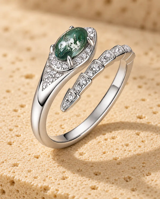 Bague Serpent Agate Mousse en Argent 925 - posée debout sur une surface claire texturée