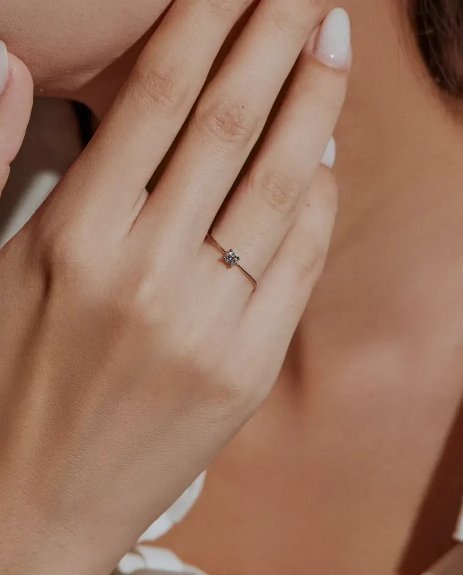 Bague Solitaire Moissanite Fine en Argent 925 - portée par un mannequin, mains près du visage