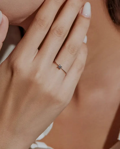 Bague Solitaire Moissanite Fine en Argent 925 - portée par un mannequin, mains près du visage