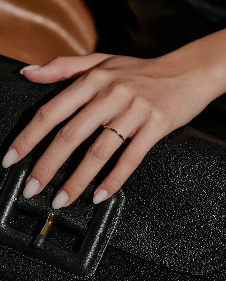 Bague Vague en Argent 925 - portée sur une main posée sur un sac noir