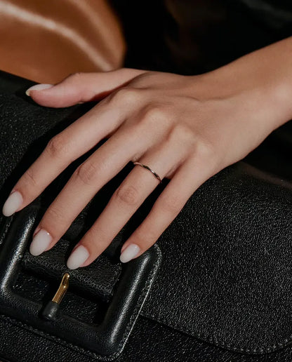 Bague Vague en Argent 925 - portée sur une main posée sur un sac noir