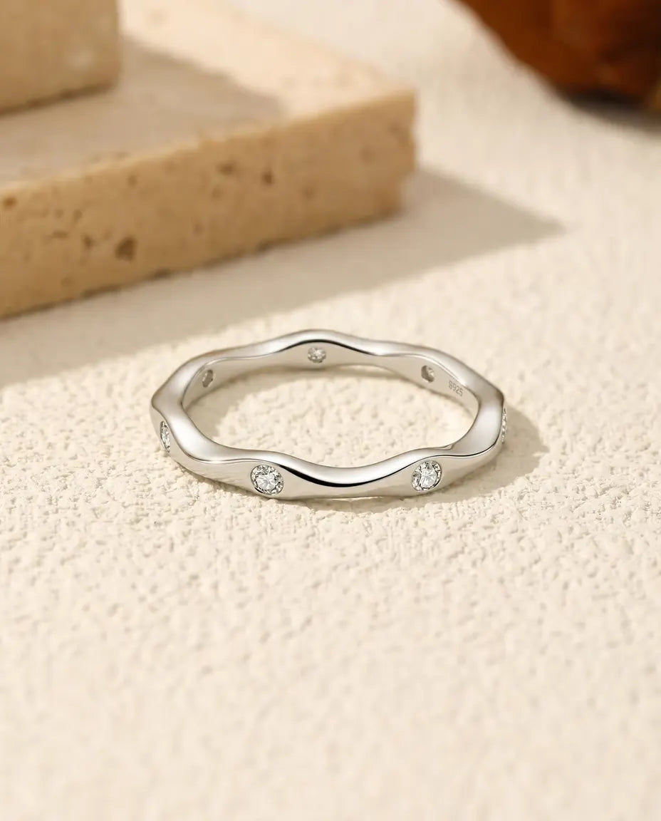 Bague Moissanite Vague en Argent 925 - posée à plat sur une surface claire texturée