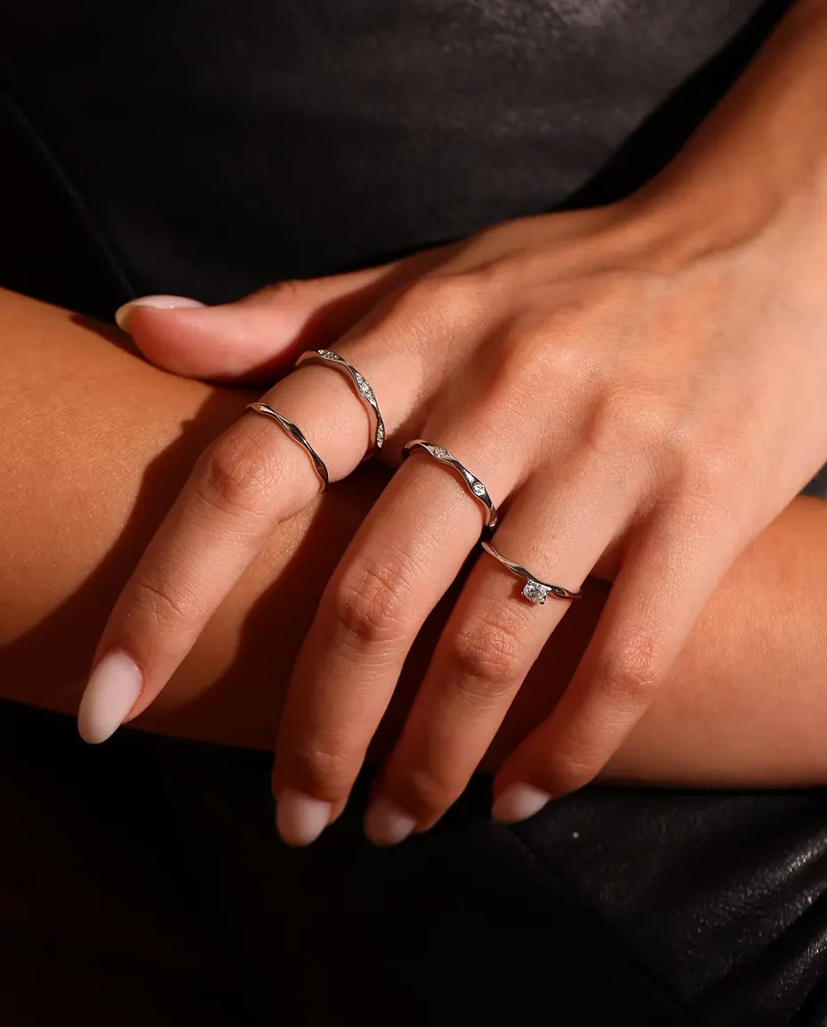 Bague Moissanite Vague en Argent 925 - portée avec d’autres bagues, gros plan sur les doigts