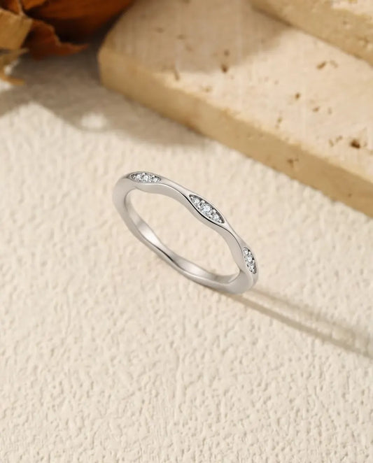 Bague Vague Moissanite en Argent 925 - posée debout sur une surface claire texturée