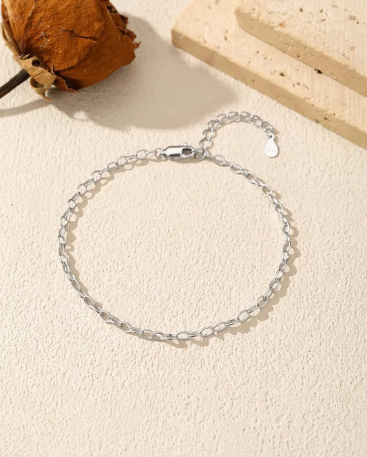 Bracelet Chaîne Forçat en Argent 925 - posé à plat sur une surface claire texturée, avec fermoir et chaînette d’extension