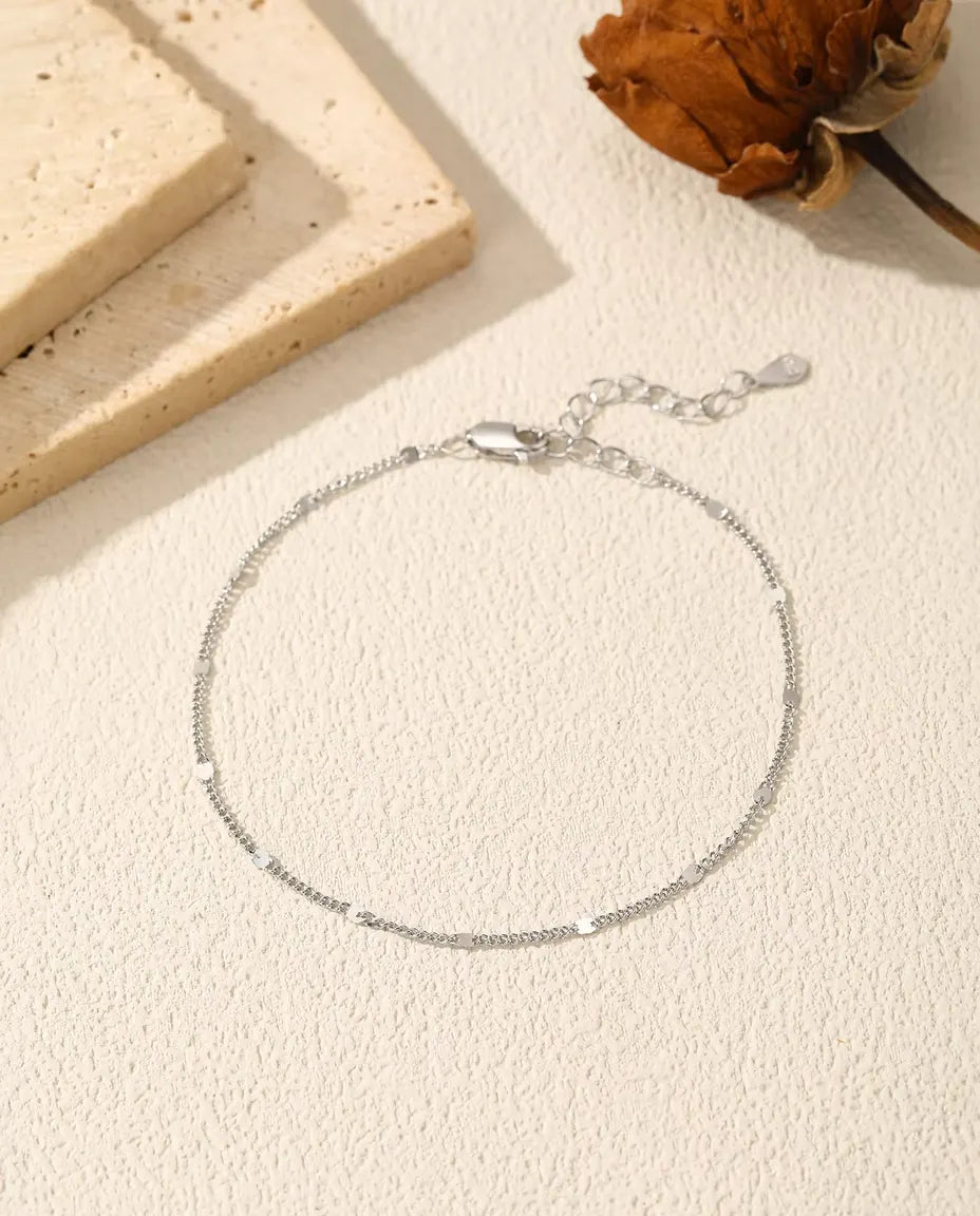 Bracelet Chaîne à Paillettes en Argent 925 - posé à plat sur une surface claire texturée, avec fermoir et chaînette d’extension