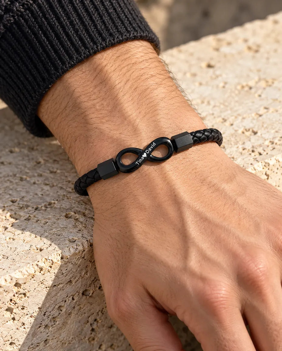 Homme portant le bracelet infini gravé noir en similicuir au poignet, avec un pull en maille anthracite