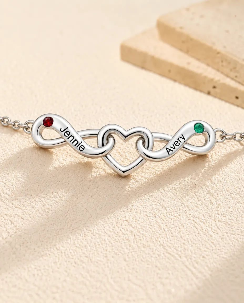 Bracelet Infini Personnalisé 2 Prénoms - deux boucles infinies autour d'un cœur - gros plan des prénoms gravés et des pierres de naissance