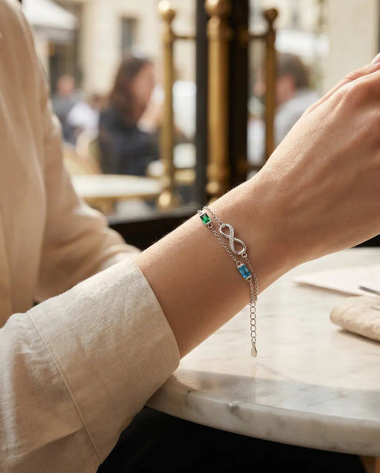 Femme portant le bracelet infini à deux pierres de naissance à une table de café