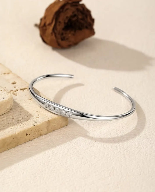 Bracelet Jonc Moissanite en Argent 925 - posé sur une dalle de travertin