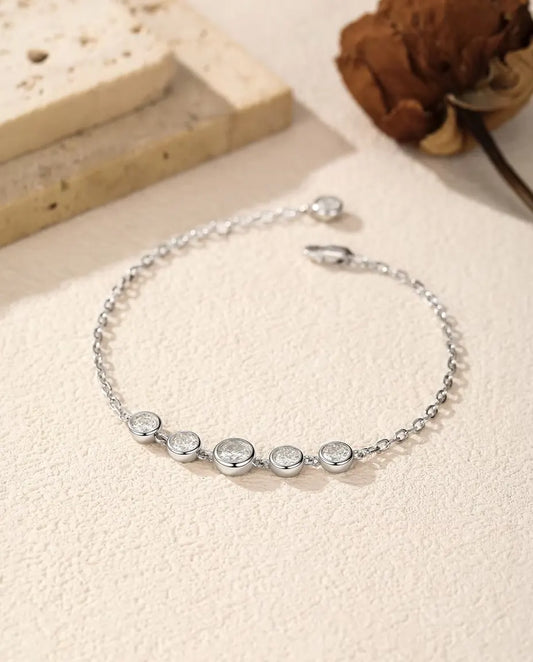 Bracelet Moissanite Serti Clos en Argent 925 - posé librement sur une surface claire, avec fermoir et chaînette d’extension