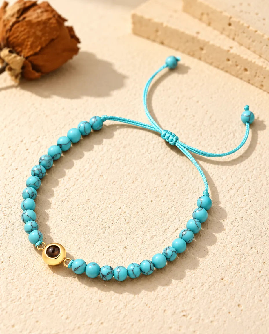Bracelet perles photo projection personnalisé : perles bleu marbré et anneau doré sur plâtre