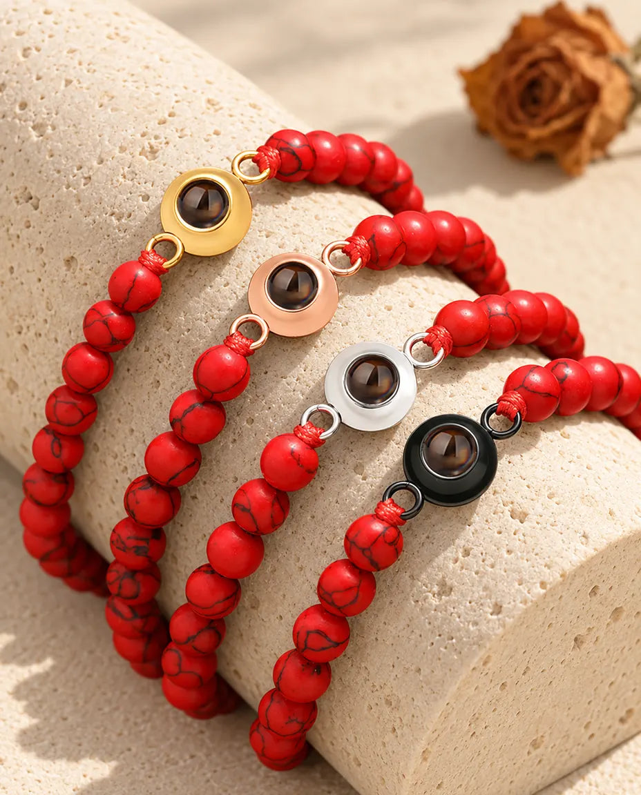 Bracelets de perles rouge marbré dans quatre couleurs de charm sur un bloc de travertin