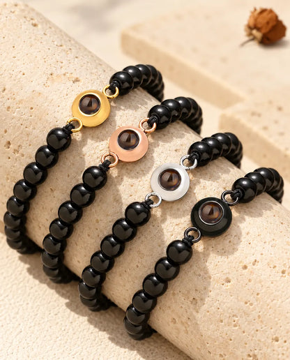 Bracelets de perles noir brillant dans les quatre couleurs de charm sur du travertin