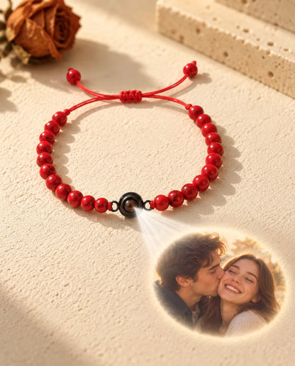 La lumière traverse la pierre brune du bracelet de perles rouges et projette la photo d'un couple