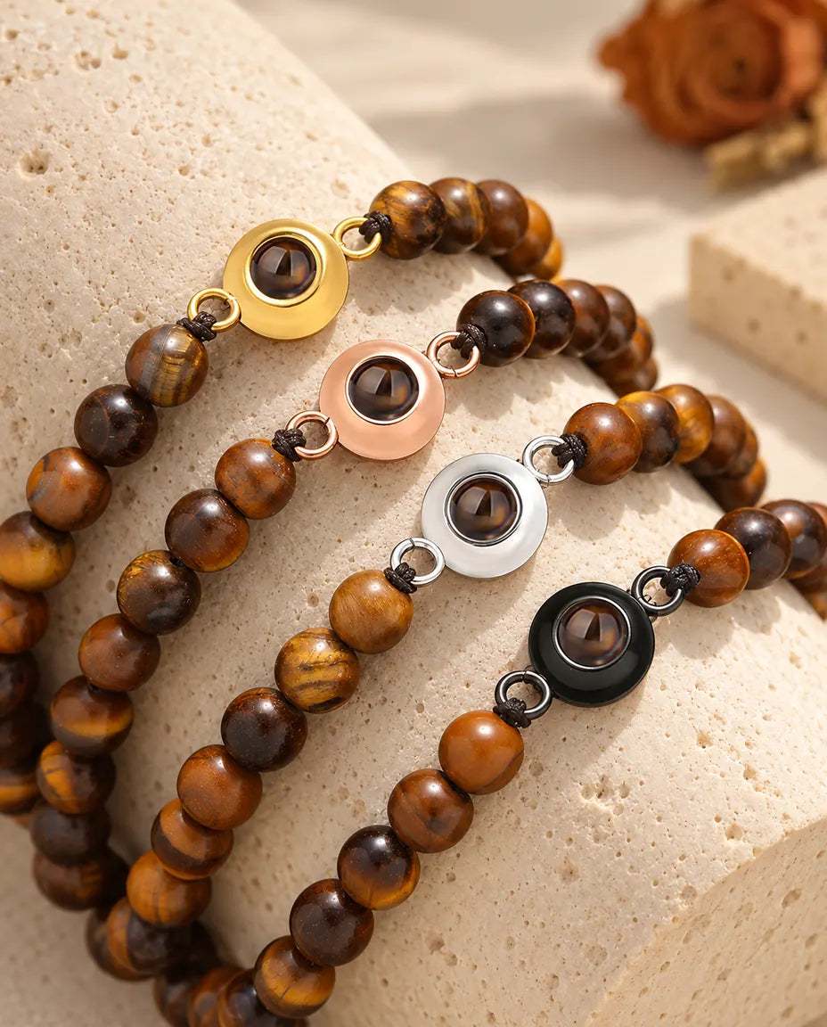 Bracelets de perles œil de tigre dans les quatre couleurs de charm sur un bloc de travertin