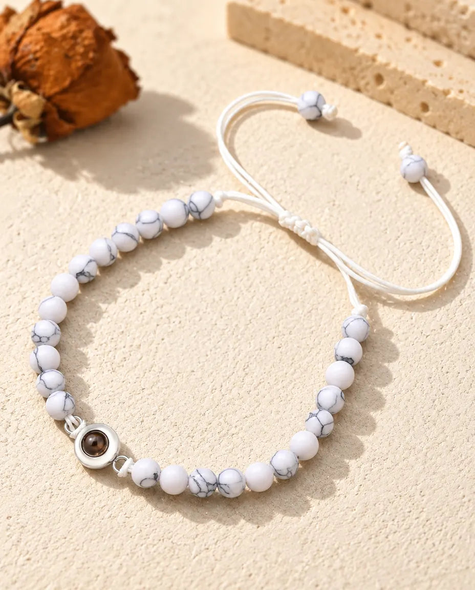 Bracelet de perles blanc marbré avec charm argenté et nœud coulissant