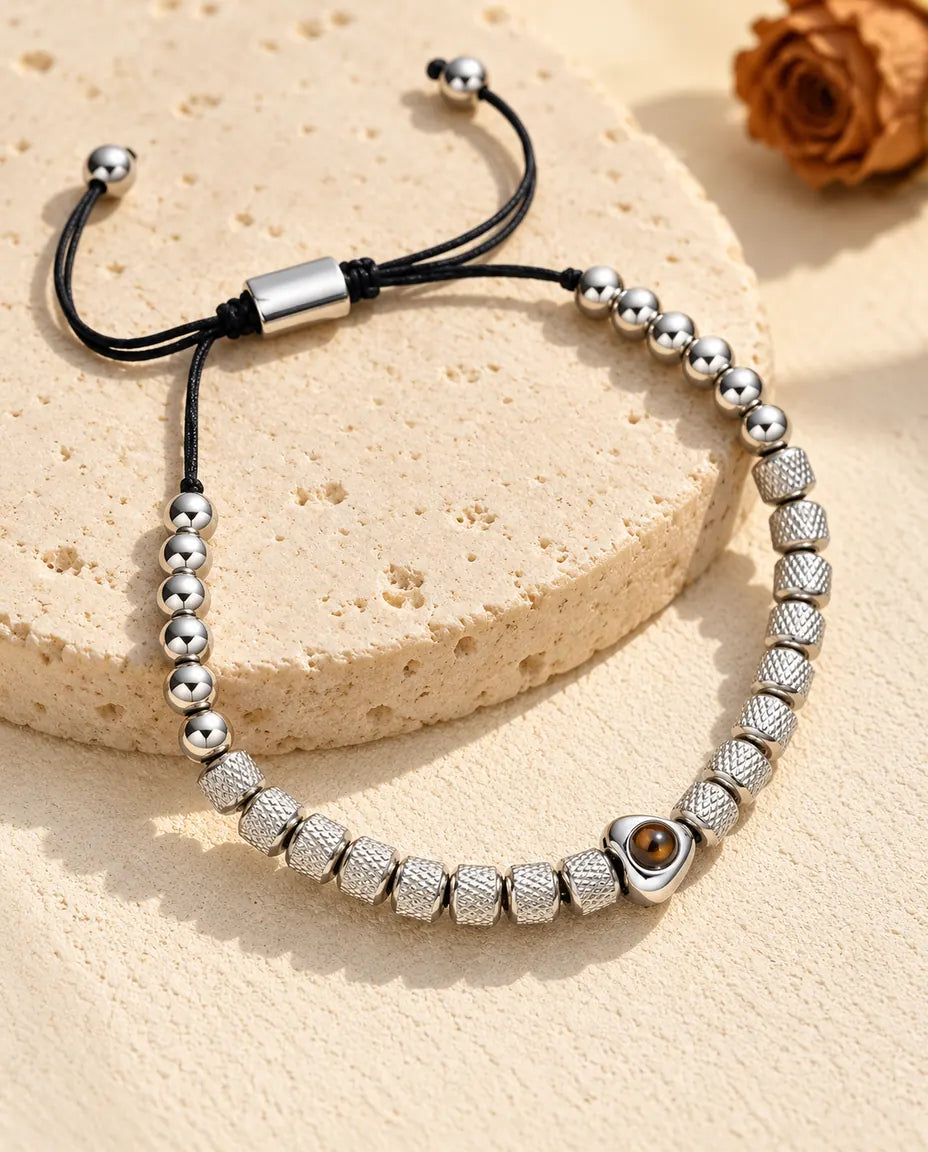 Bracelet de perles photo projection personnalisé argenté, perle cœur et perles texturées, sur du travertin