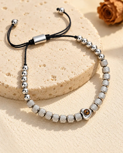Bracelet de perles photo projection personnalisé argenté, perle cœur et perles texturées, sur du travertin