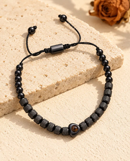 Bracelet noir à perles texturées, perle cœur, coulisseau et extrémités du cordon