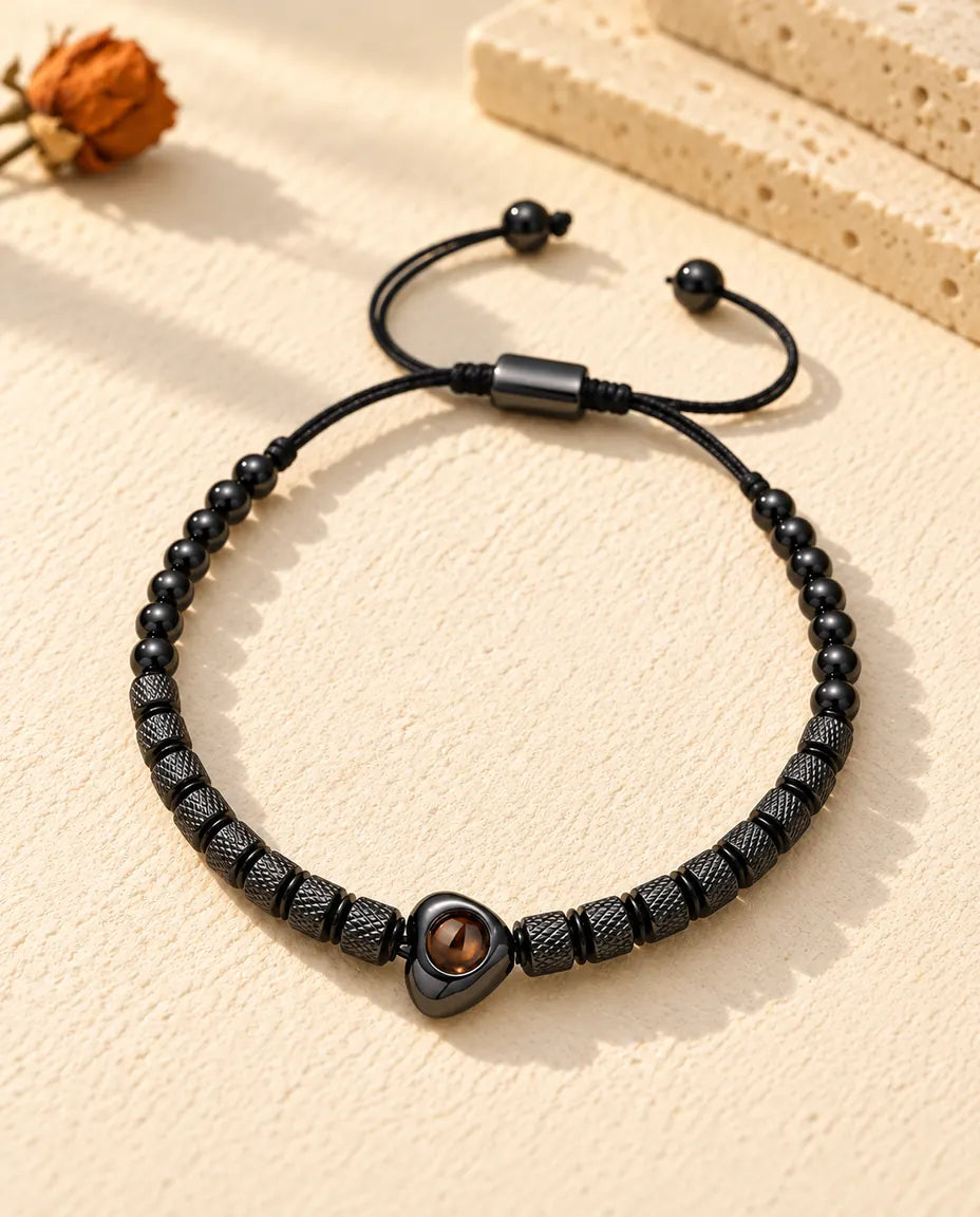Vue de dessus du bracelet de perles noir à perle cœur sur du plâtre crème
