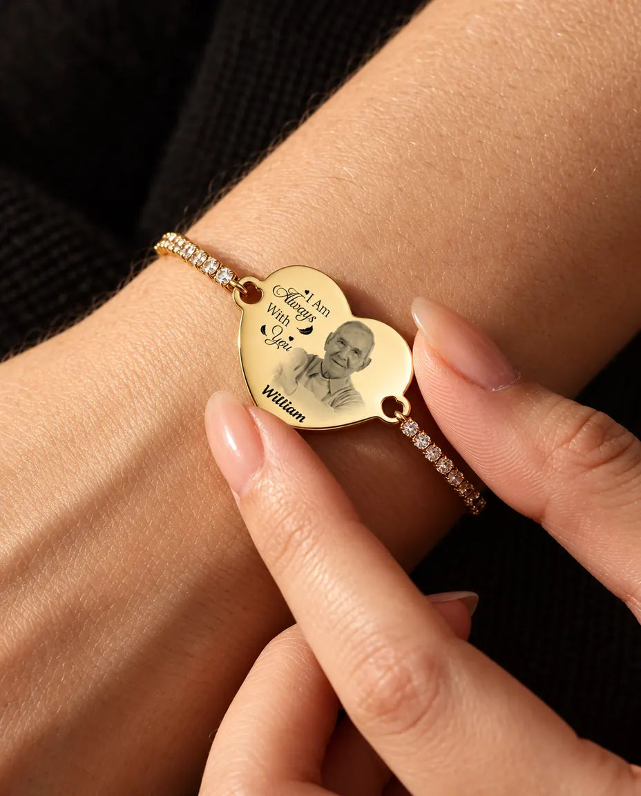 Bout des doigts tenant le cœur photo gravé doré, le bracelet porté au poignet
