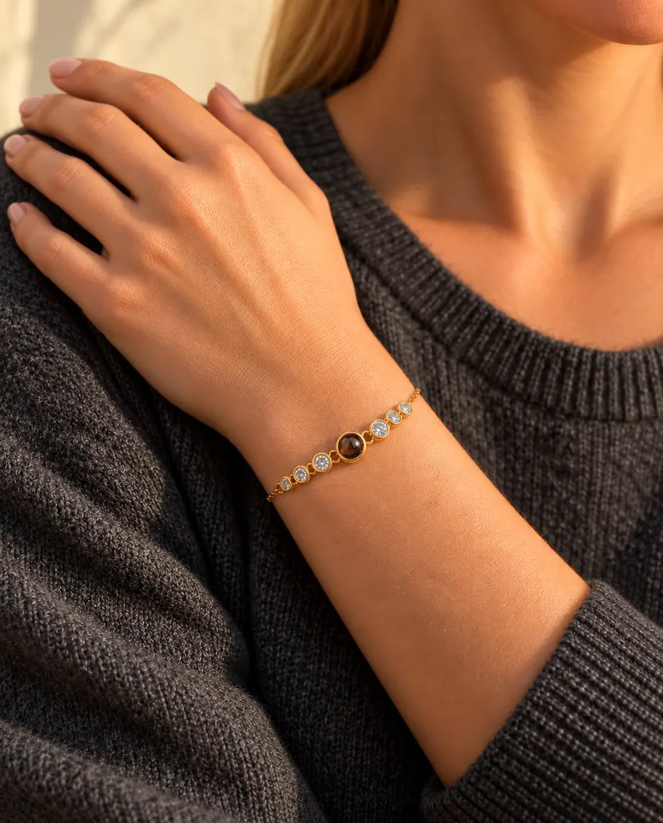 Gros plan du bracelet doré à zircons au poignet, la main posée sur son épaule