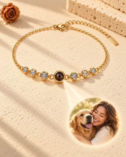 La lumière traversant la pierre brune du bracelet doré projette la photo ronde d'une femme et son chien