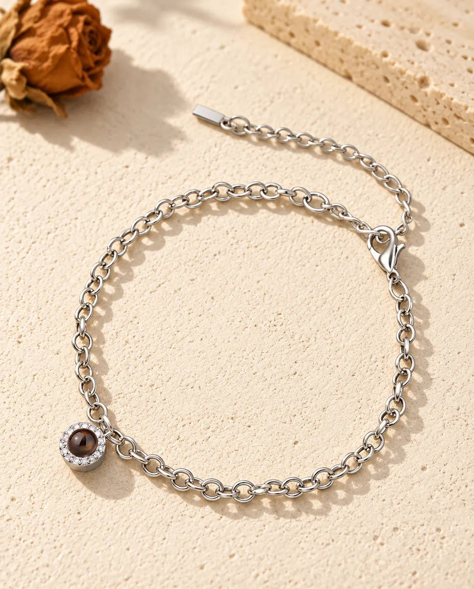 Bracelet photo projection personnalisé argenté avec un petit charm pavé de zircons sur une fine chaîne