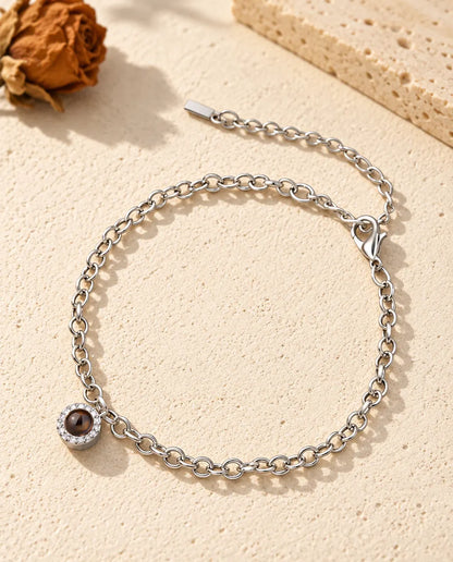Bracelet photo projection personnalisé argenté avec un petit charm pavé de zircons sur une fine chaîne