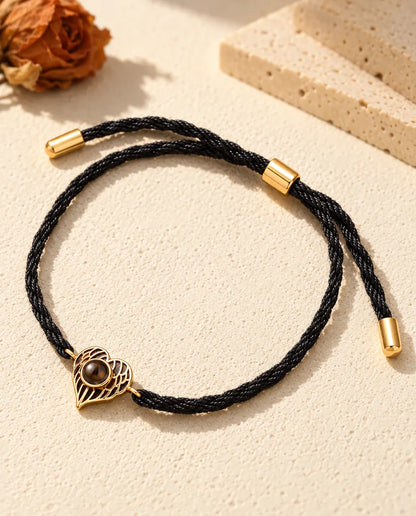 Bracelet souvenir doré cœur ailes d'ange avec coulisseau et embouts sur cordon noir torsadé