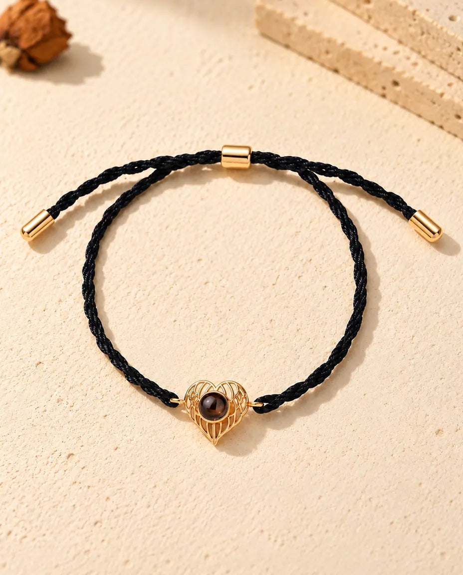 Vue de dessus du bracelet cœur ailes d'ange doré avec son coulisseau réglable