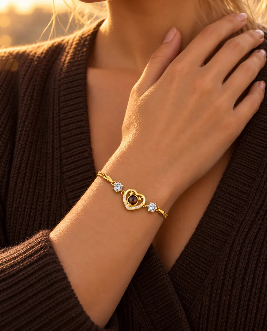 Gros plan du bracelet cœur doré aux zircons au poignet, la main posée sur la clavicule